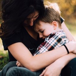 homeless woman hugging child on her lap